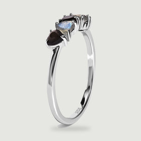 An upright side view shows the slender silver band and raised prong settings beneath the heart-shaped stones.