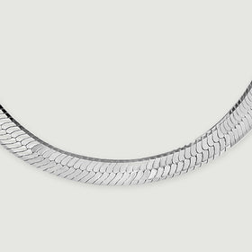 Bright and dark reflections reveal the fine interlocking links of the silver necklace.