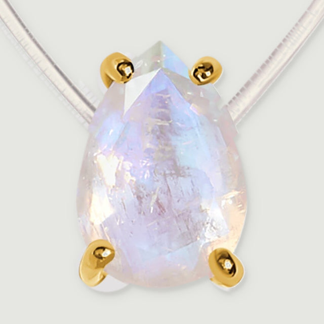 Four yellow gold prongs hold a translucent moonstone with pale blue and peach reflections.