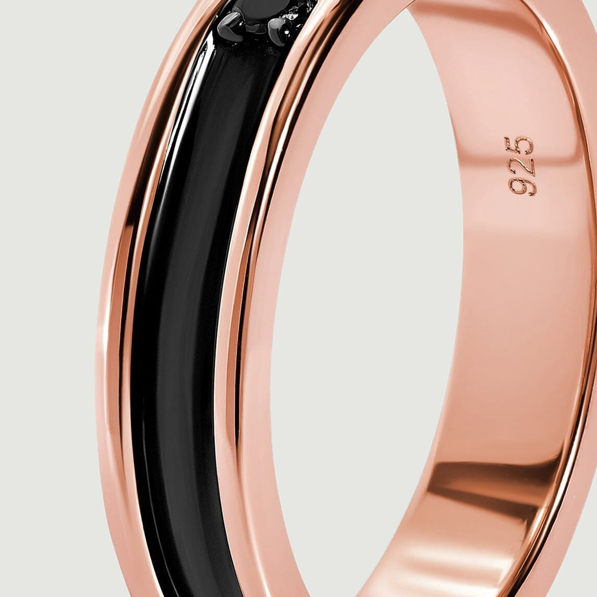 A close view shows the curved black inlay bordered by smooth rose gold rails.