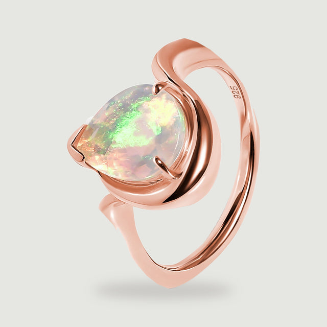 An angled view shows the pear-shaped opal, polished rose gold setting and circular band.