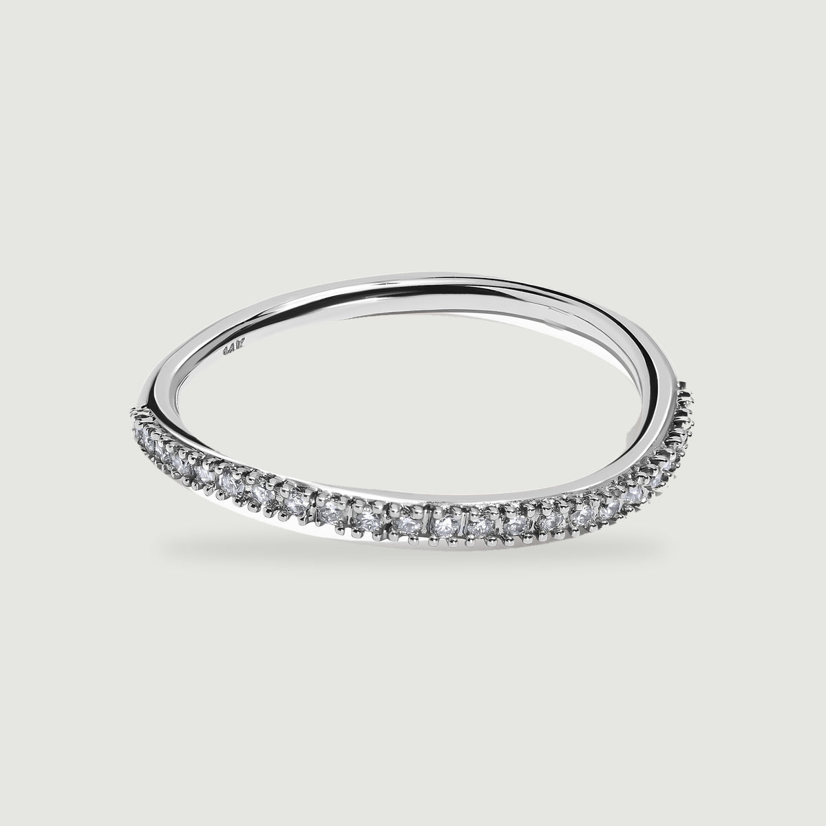 A polished white gold ring displays its open center and diamond-set front edge.