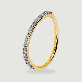 A yellow gold ring is shown from the side with bright diamond tips along its narrow curved band.