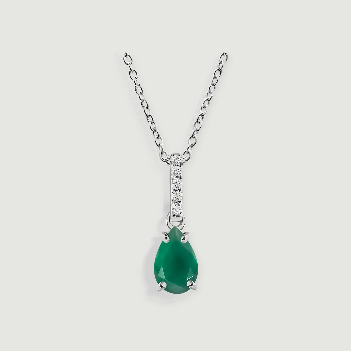 A silver chain holds a green pear-shaped pendant beneath a narrow diamond-set bail.