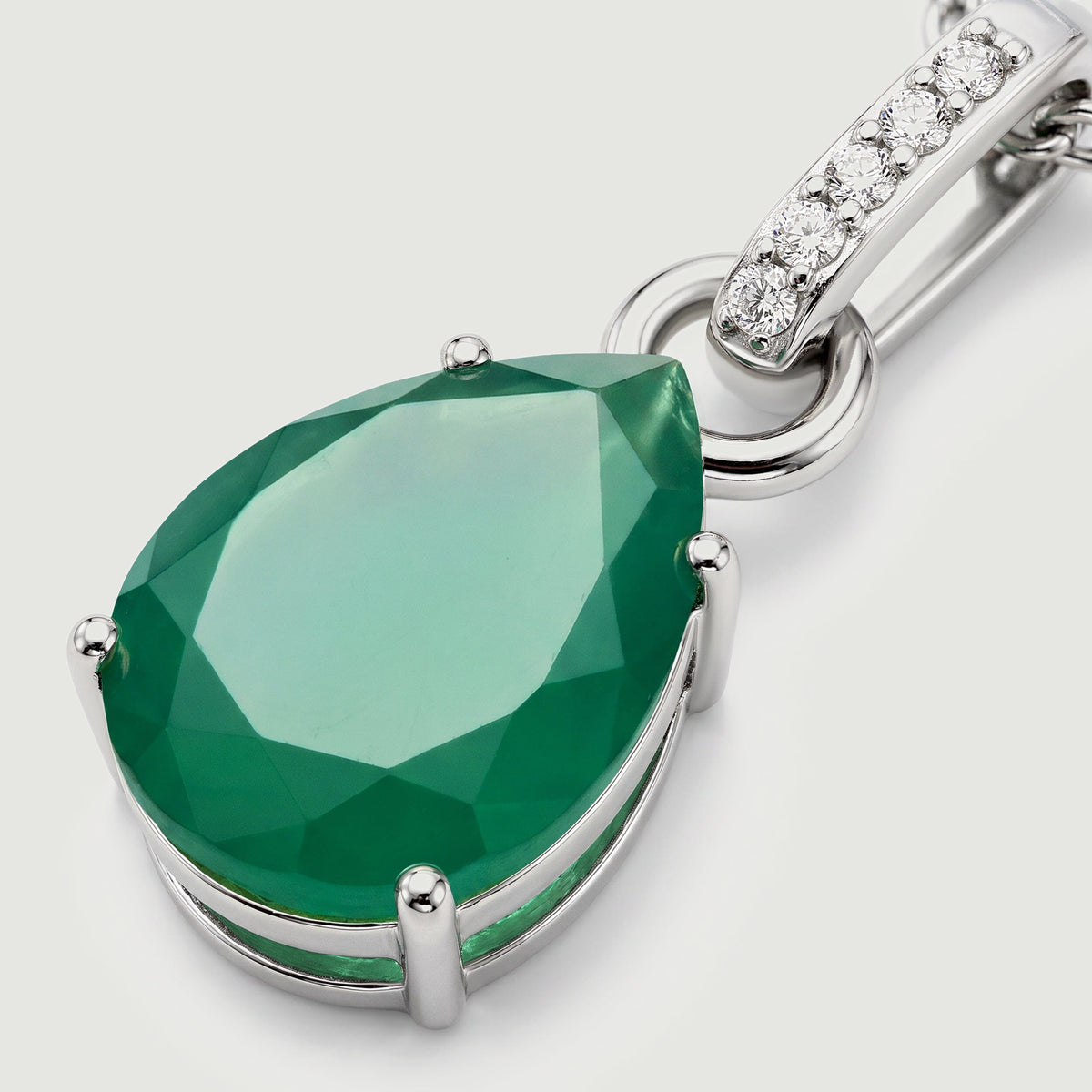 The angled silver setting reveals the raised green gemstone and the connecting ring below the bail.