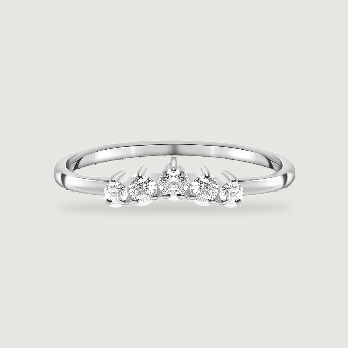 A complete sterling silver ring with five round white zircon stones rests on a light gray background.