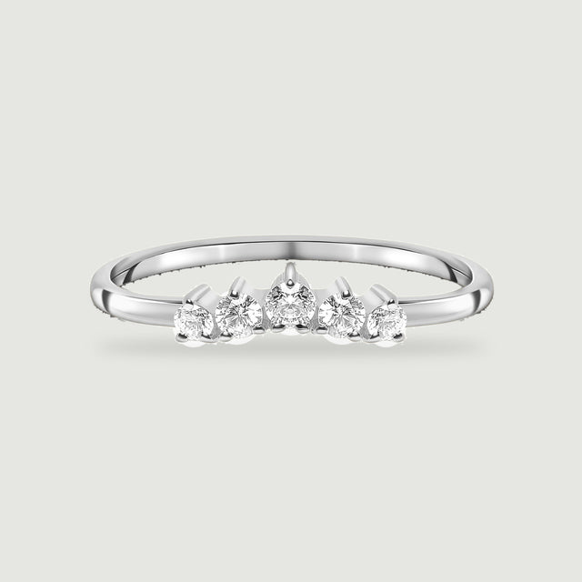 A complete sterling silver ring with five round white zircon stones rests on a light gray background.