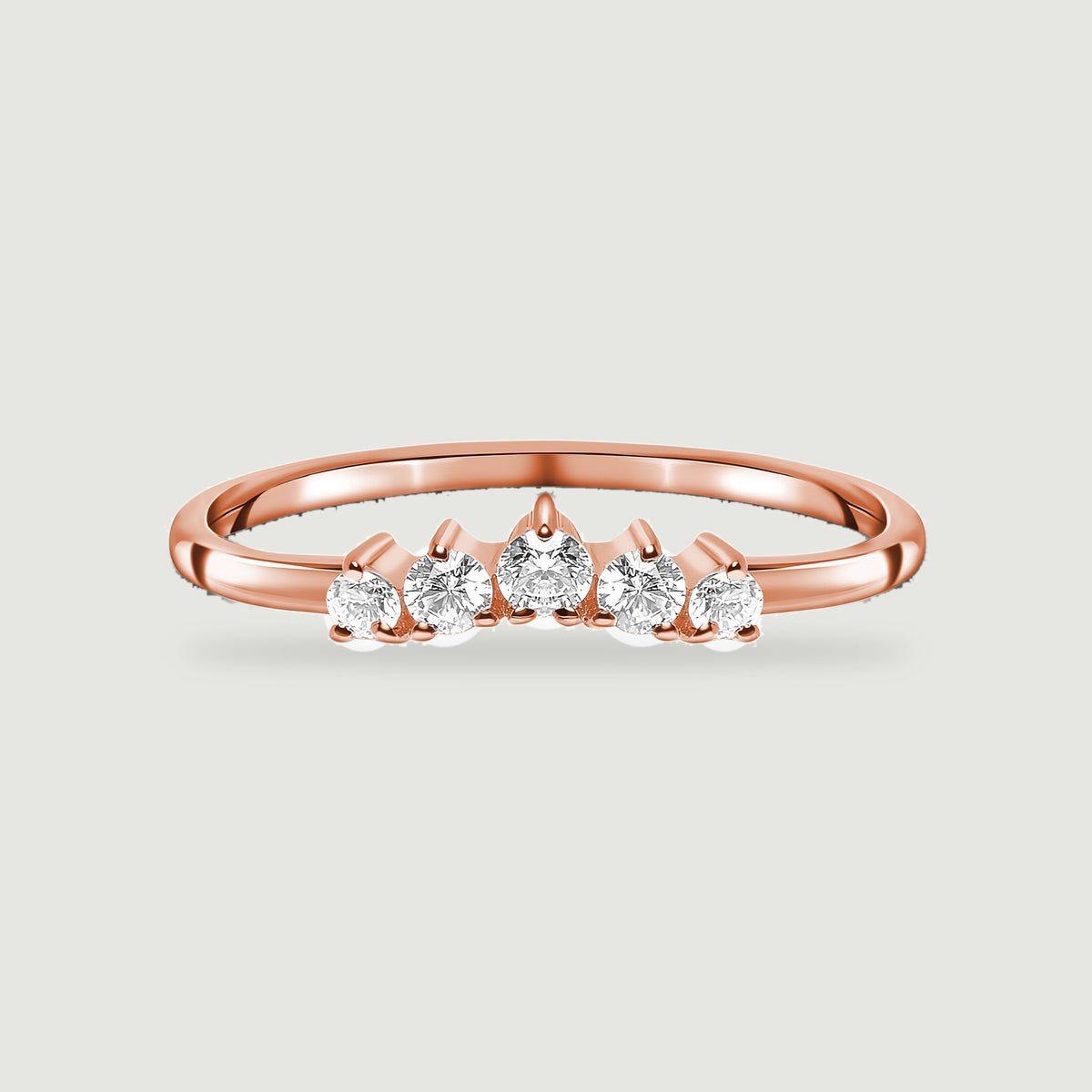 A polished rose gold vermeil band holds a curved row of five clear round stones against a light gray backdrop.