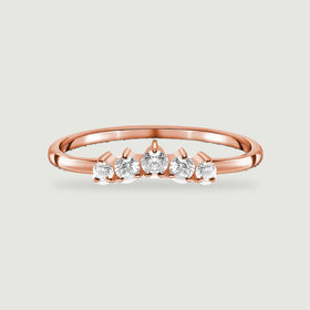 A polished rose gold vermeil band holds a curved row of five clear round stones against a light gray backdrop.