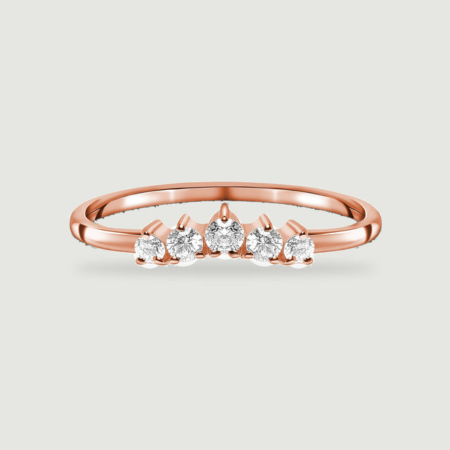 A polished rose gold vermeil band holds a curved row of five clear round stones against a light gray backdrop.