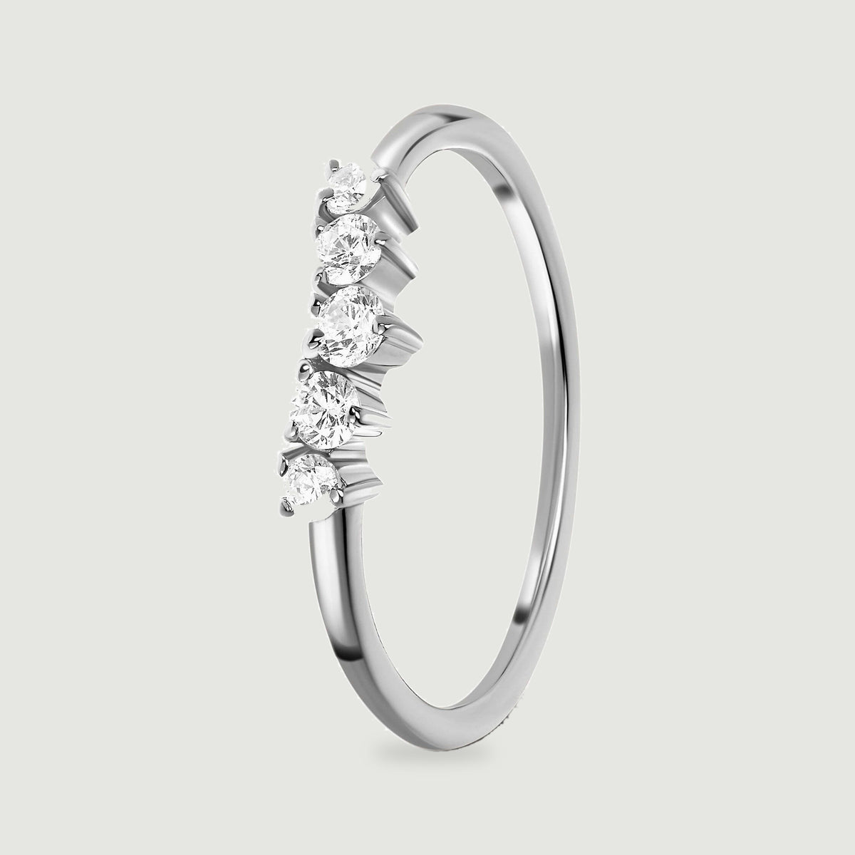 An upright silver ring reveals the raised settings beneath five white zircon stones and its slim polished band.