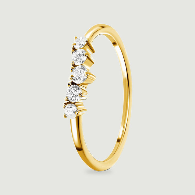 The angled yellow gold vermeil ring shows its curved shank and the side walls of five zircon settings.