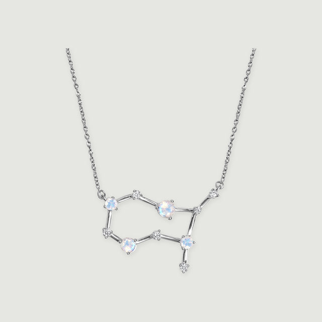 A sterling silver necklace shows an open constellation pendant suspended from a fine link chain on light gray.