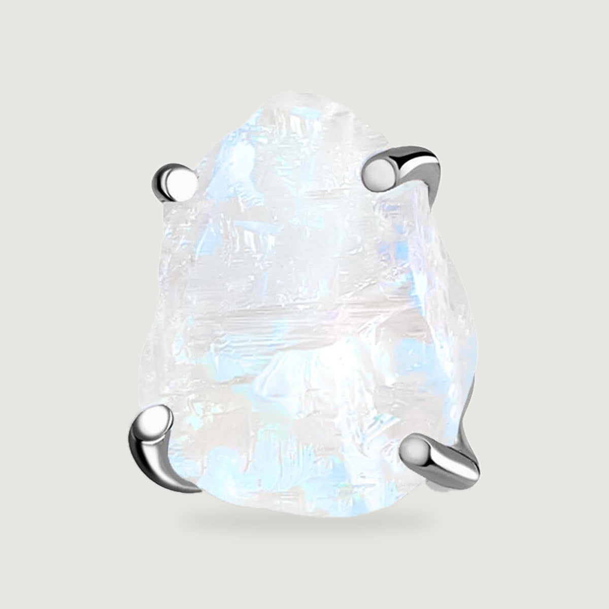 A close view of one raw moonstone stud shows blue flashes and four polished silver prongs.