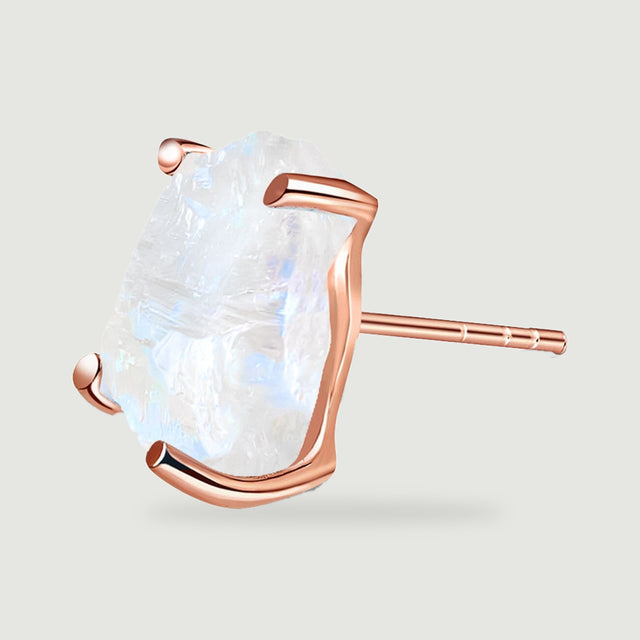 A rose gold stud is shown in profile with its pale rough stone and slender earring post.
