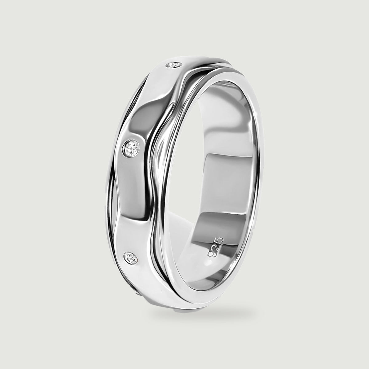 An upright sterling silver ring reveals its rounded inner band, wavy outer rails, and three visible white stones.
