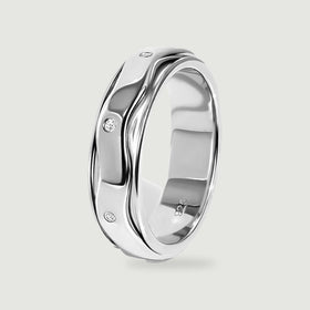 An upright sterling silver ring reveals its rounded inner band, wavy outer rails, and three visible white stones.