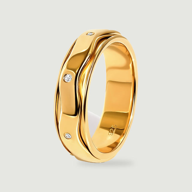 The yellow gold vermeil ring stands at an angle with white stones and polished curved edges visible from the side.