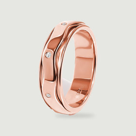 A side view of the rose gold vermeil ring shows its reflective inner band and white stones along the wavy outer surface.