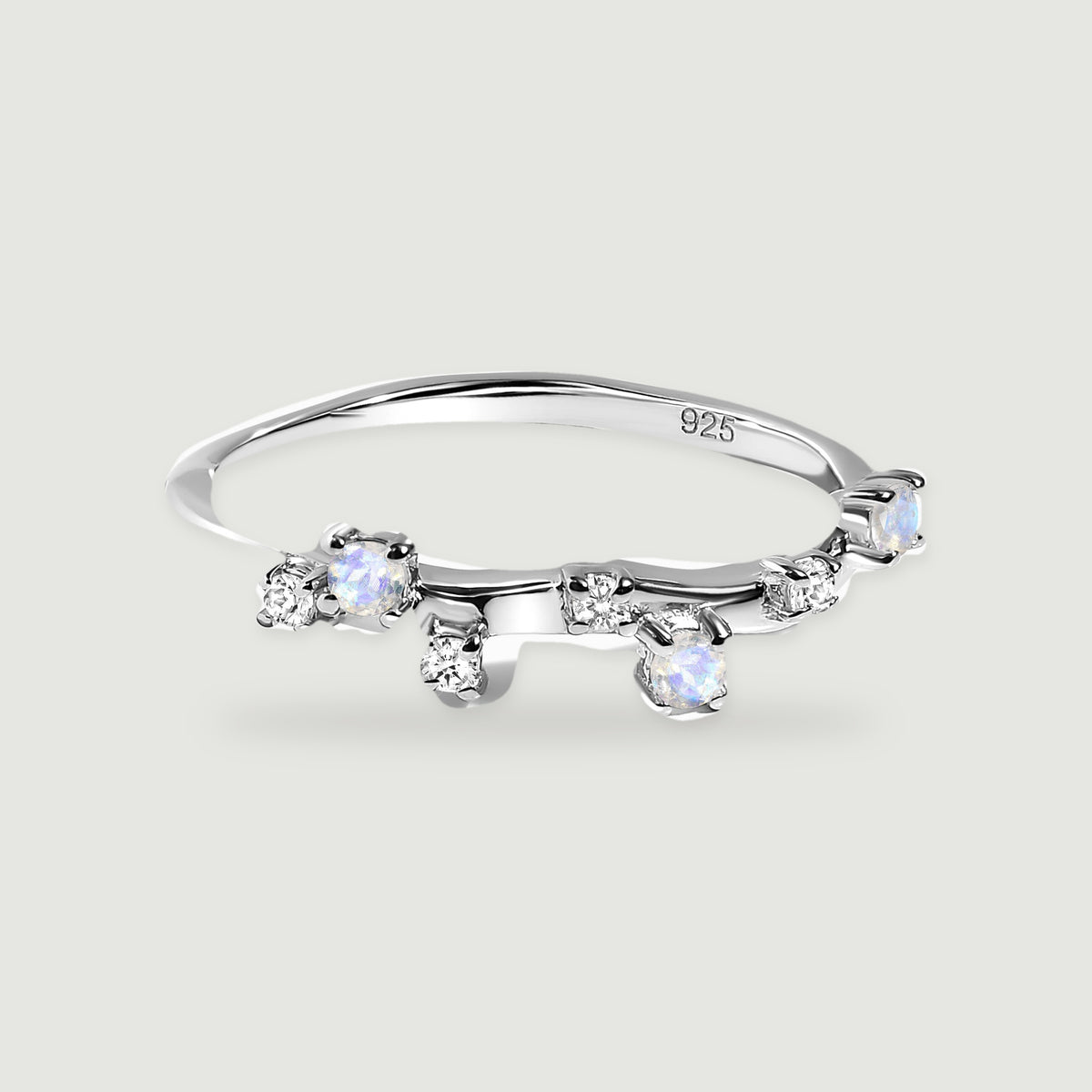 A polished sterling silver ring has small blue-flashing round stones and clear accents along its curved band.