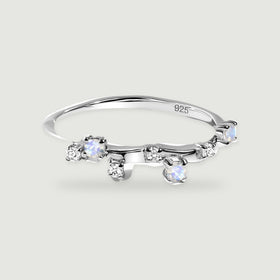 A polished sterling silver ring has small blue-flashing round stones and clear accents along its curved band.