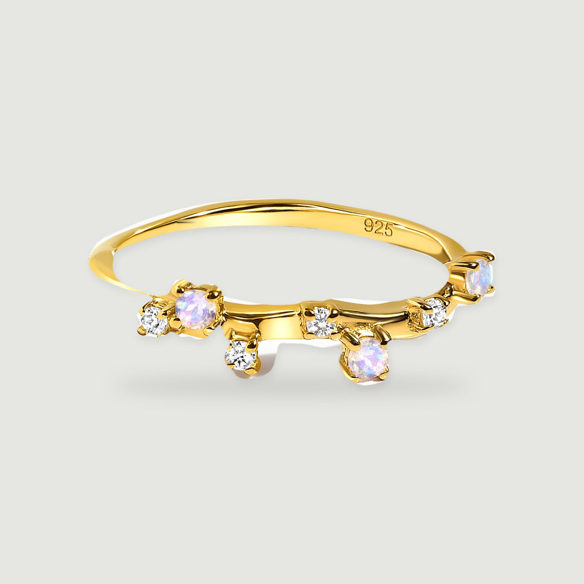 A yellow gold vermeil ring shows scattered pale round stones and clear gems in raised prong settings.