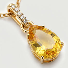 A close view shows the gold-toned prongs, yellow citrine facets, and five clear stones along the elongated bail.