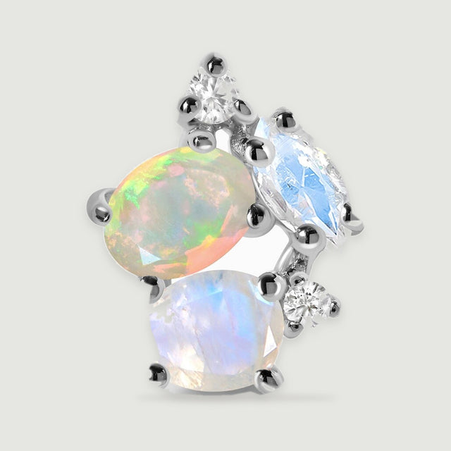 A close view of a silver earring reveals the colored flashes of its opal and the prongs around the pale stones.