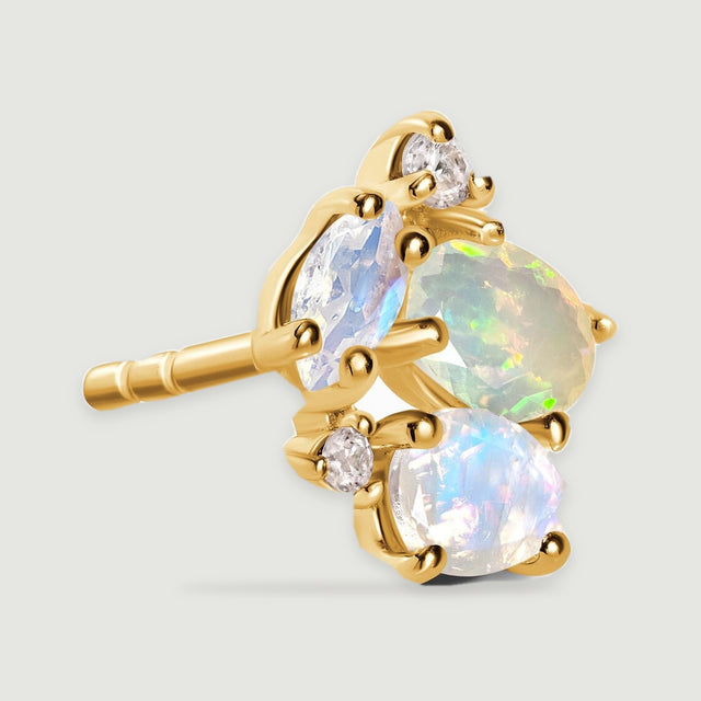 A yellow gold stud earring is shown at an angle with its straight post extending behind the stone cluster.