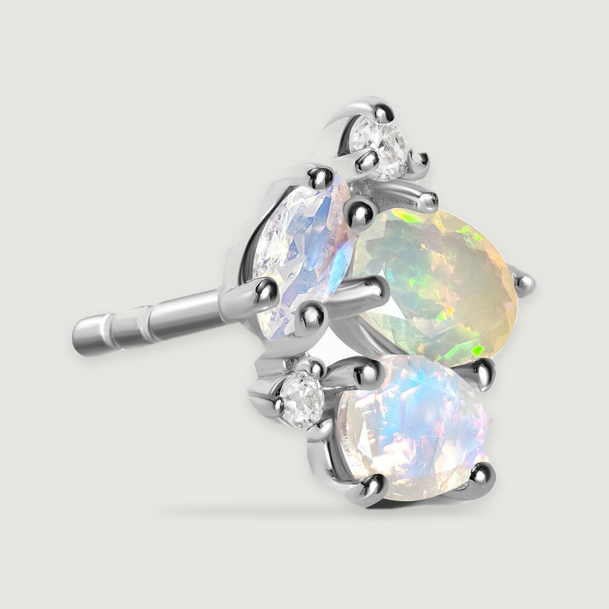 An angled silver stud displays its polished setting and the grooved end of the earring post.