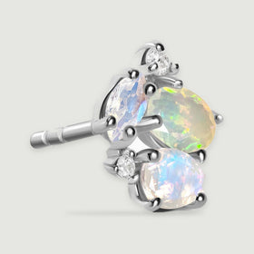 An angled silver stud displays its polished setting and the grooved end of the earring post.