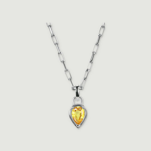 A white rhodium plated chain holds a pear-shaped citrine pendant on a pale grey background.