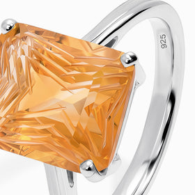 A close angled view shows the raised citrine setting and polished silver shoulders with a 925 stamp inside the band.