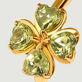 A close view shows faceted green peridot hearts held by yellow gold vermeil prongs.