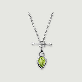 A silver-tone chain necklace has a green pear-shaped stone beneath a polished horizontal bar on a light grey background.