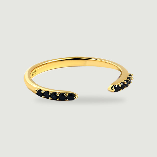 A yellow gold vermeil ring curves around an open gap between two rows of black stones.