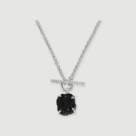 A black obsidian pendant hangs below a crystal-set silver bar and round clasp on a silver chain against a light gray background.