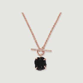 A rose gold vermeil necklace shows four curved prongs around a black obsidian stone and a round front clasp on light gray.