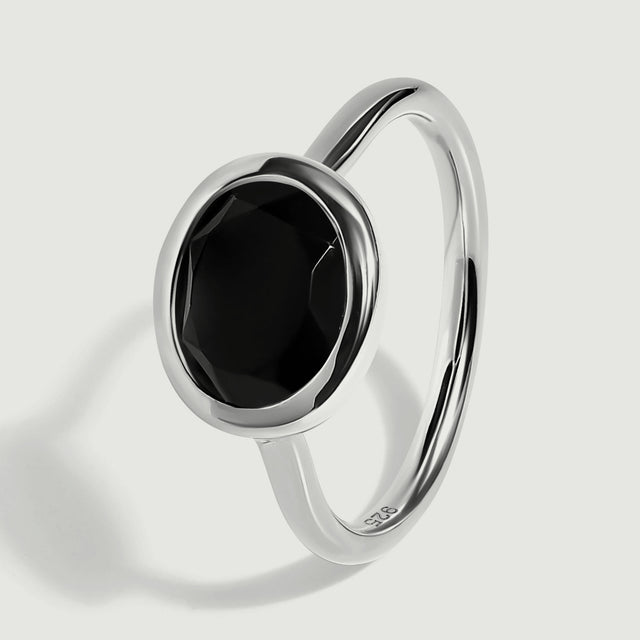 The sterling silver ring is shown upright at an angle with a narrow polished band.