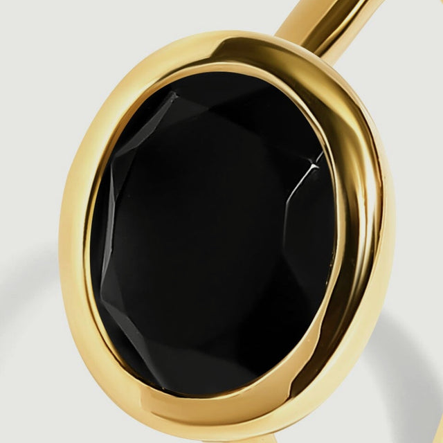 A close view shows dark facets inside the rounded yellow gold vermeil bezel.