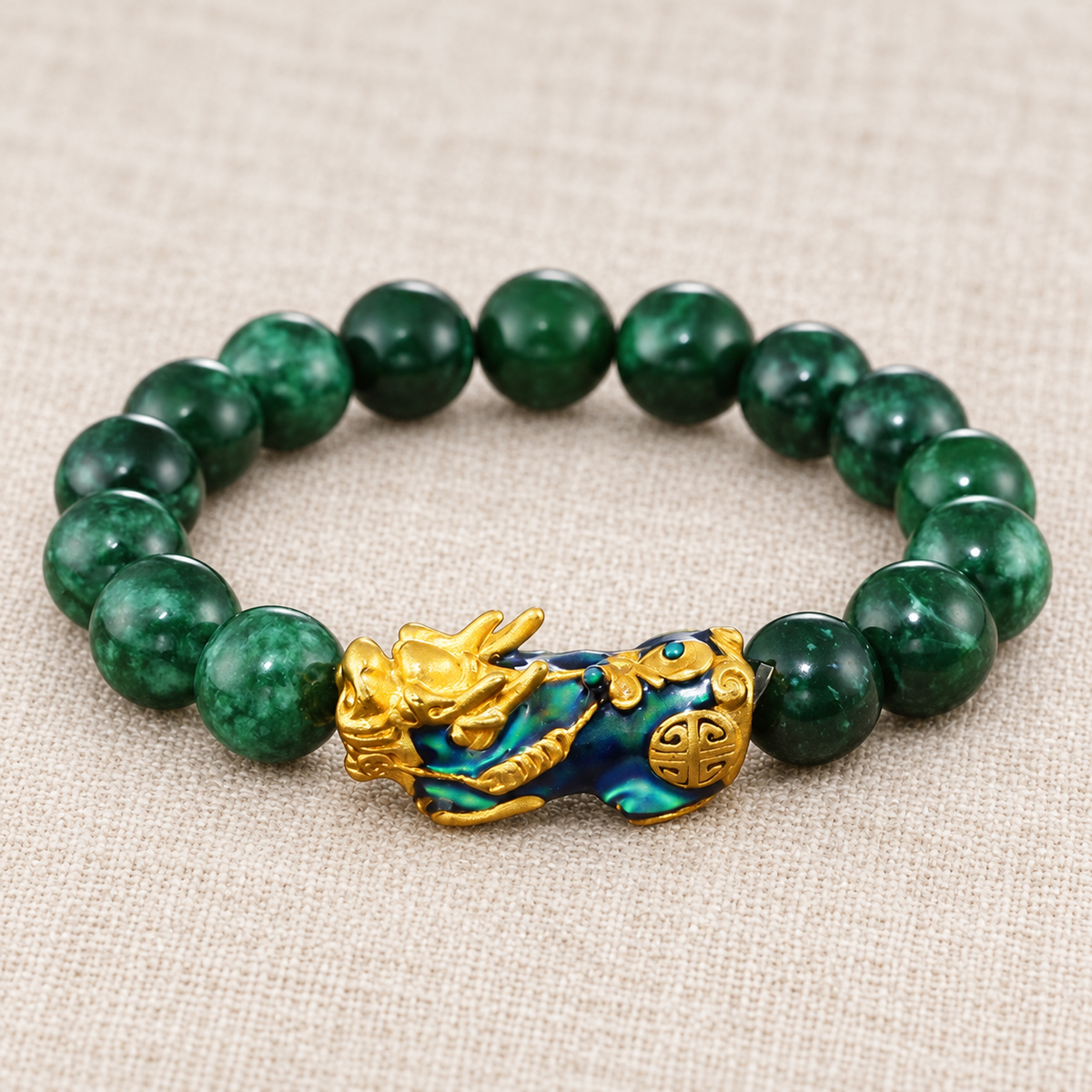 Close view of dark green jade beads and a gold-tone PiXiu charm.
