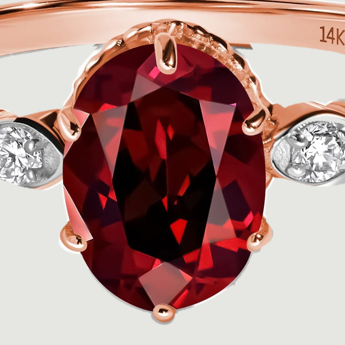 A close view shows the red garnet facets and rose gold prongs around the oval stone.