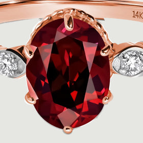 A close view shows the red garnet facets and rose gold prongs around the oval stone.