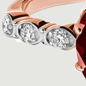 Three round diamonds sit in bright circular settings along one rose gold shoulder.