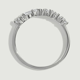 The side of a silver ring reveals raised prongs and a slim rounded band.