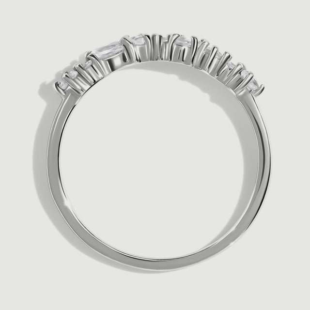 The side of a silver ring reveals raised prongs and a slim rounded band.