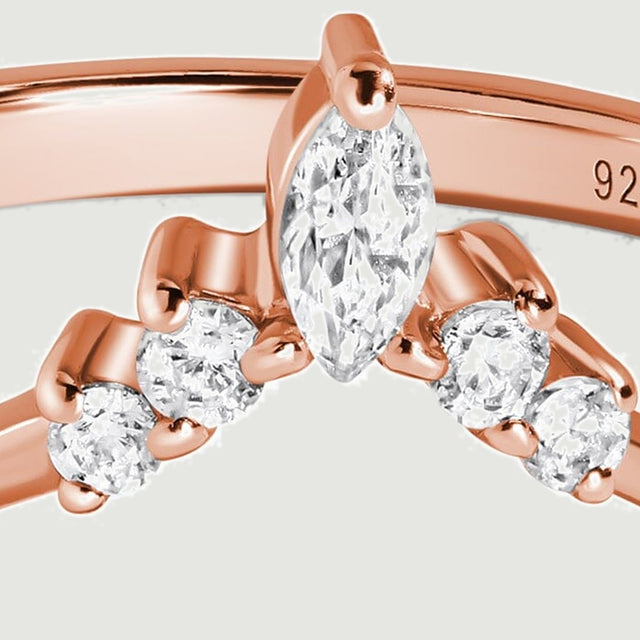 A close view shows the central marquise stone flanked by four round stones in rose gold prongs.