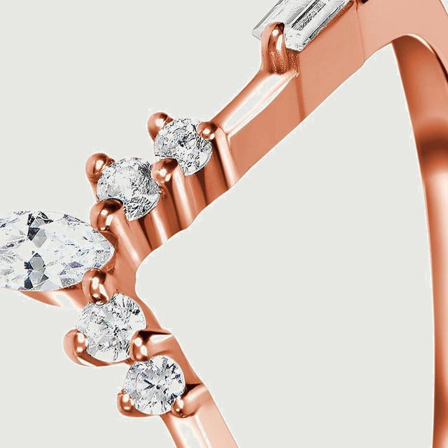 Clear faceted stones and rose gold prongs are visible along the sloping shoulder of the ring.