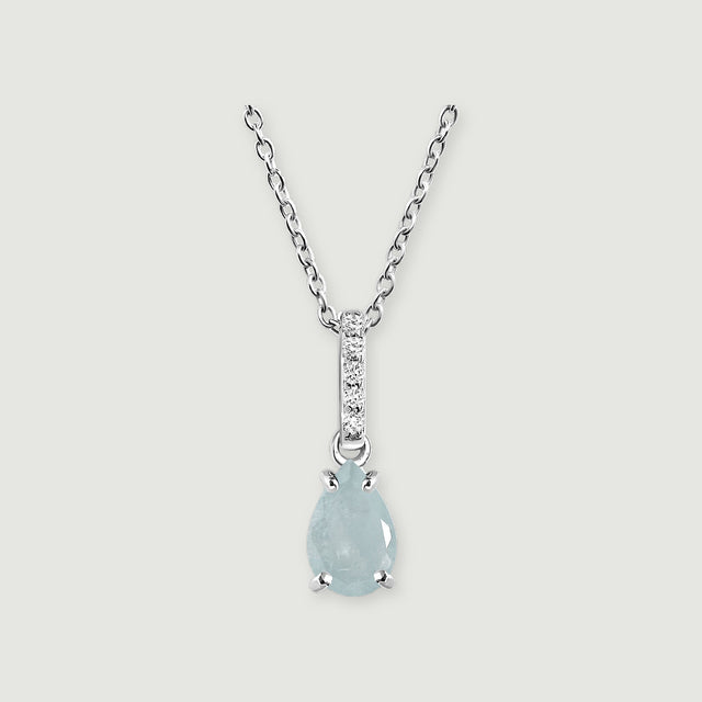 A silver chain frames a pale blue pear-shaped stone beneath a narrow row of round clear stones on light gray.