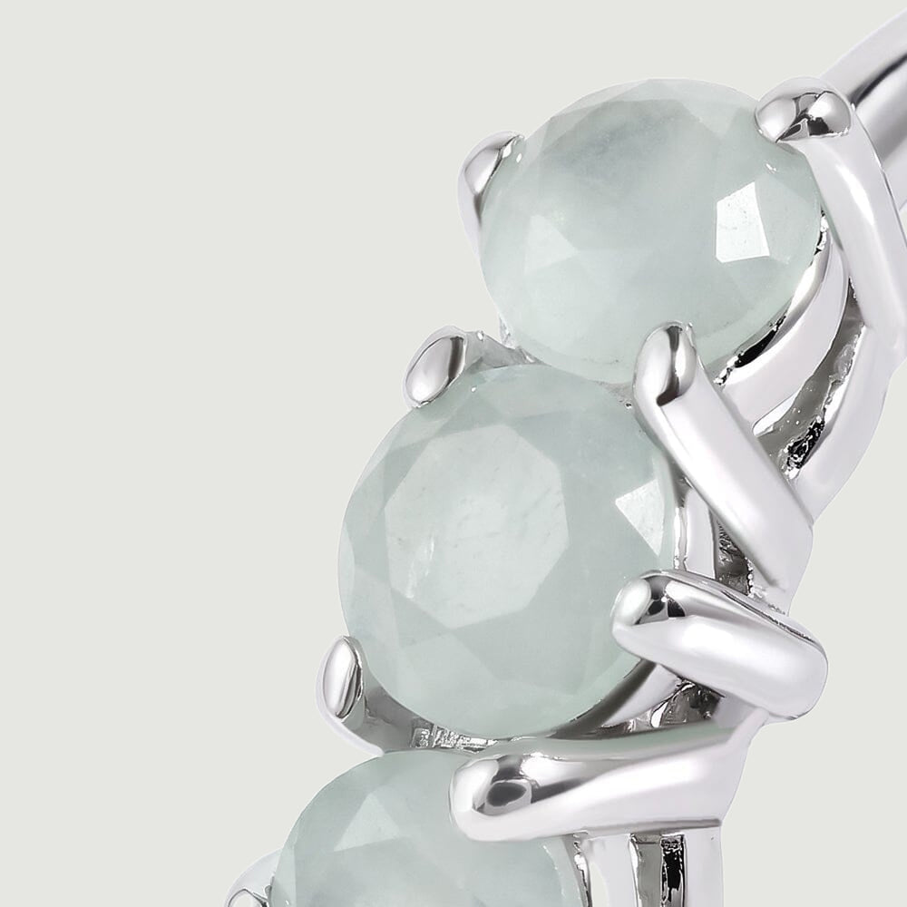 A close view shows pale blue round aquamarines held by polished silver-toned prongs.